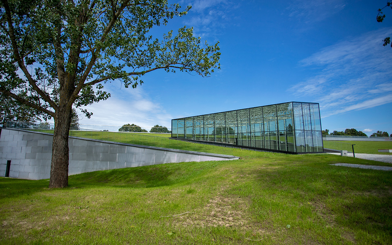 Budynek Muzeum Bitwy pod Grunwaldem wraz ze szklanym sufitem wychodzącym poza linię dachu budynku. 